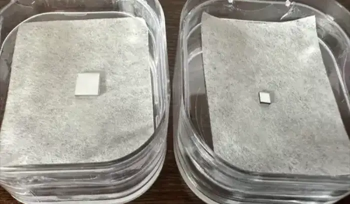 Two clear containers with a square shaped piece of plastic.